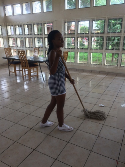 An MI student mopping the Old Age Home common space.
